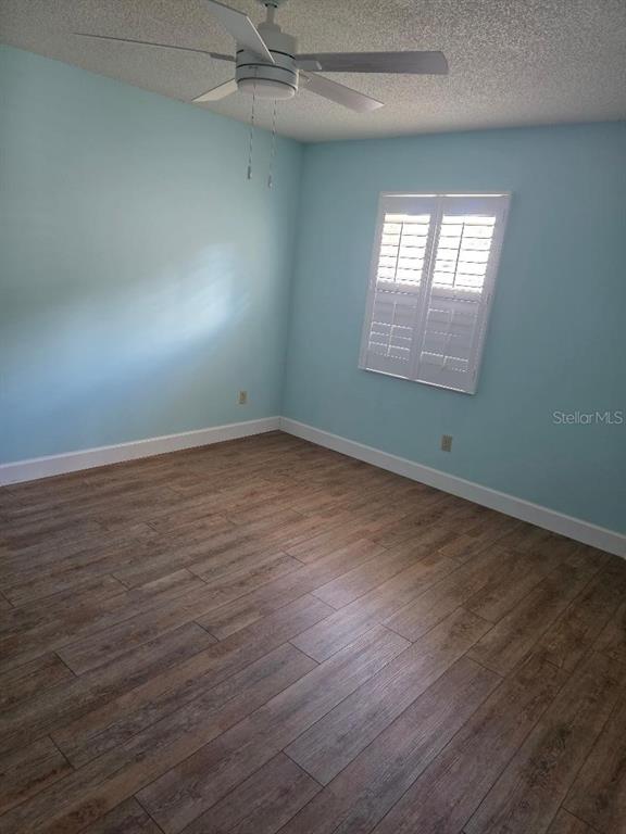 9028 Southwest 91st Circle Ocala, FL 34481 - Photo 19 of 31 an empty room with wooden floor and windows