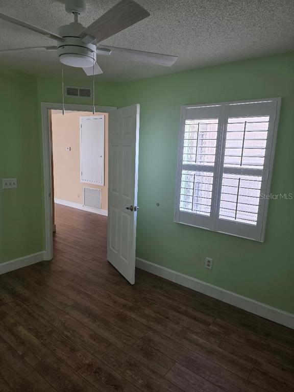 9028 Southwest 91st Circle Ocala, FL 34481 - Photo 22 of 31 an empty room with wooden floor a ceiling fan and a window