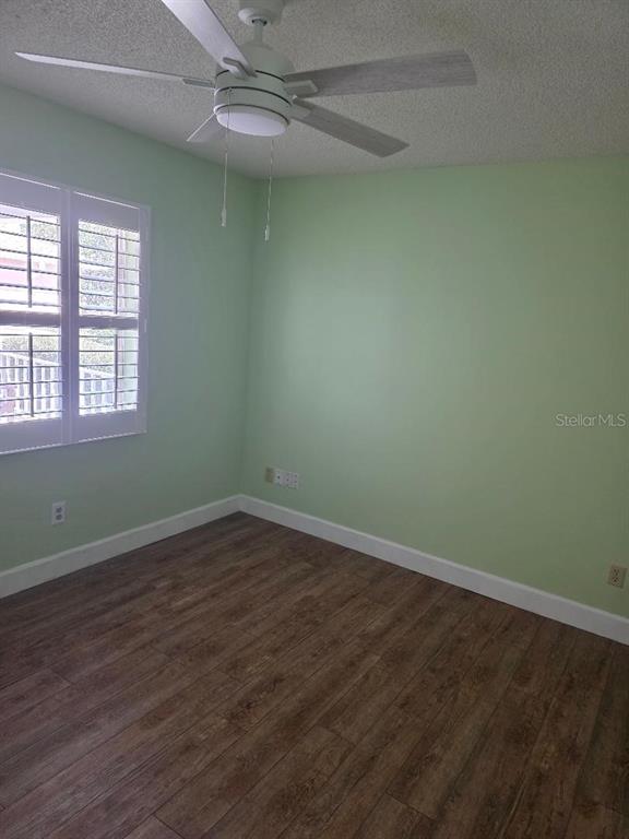 9028 Southwest 91st Circle Ocala, FL 34481 - Photo 23 of 31 an empty room with wooden floor fan and windows