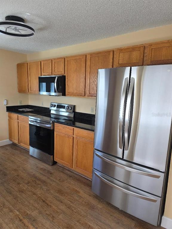 9028 Southwest 91st Circle Ocala, FL 34481 - Photo 25 of 31 a kitchen with stainless steel appliances granite countertop a refrigerator and a stove top oven