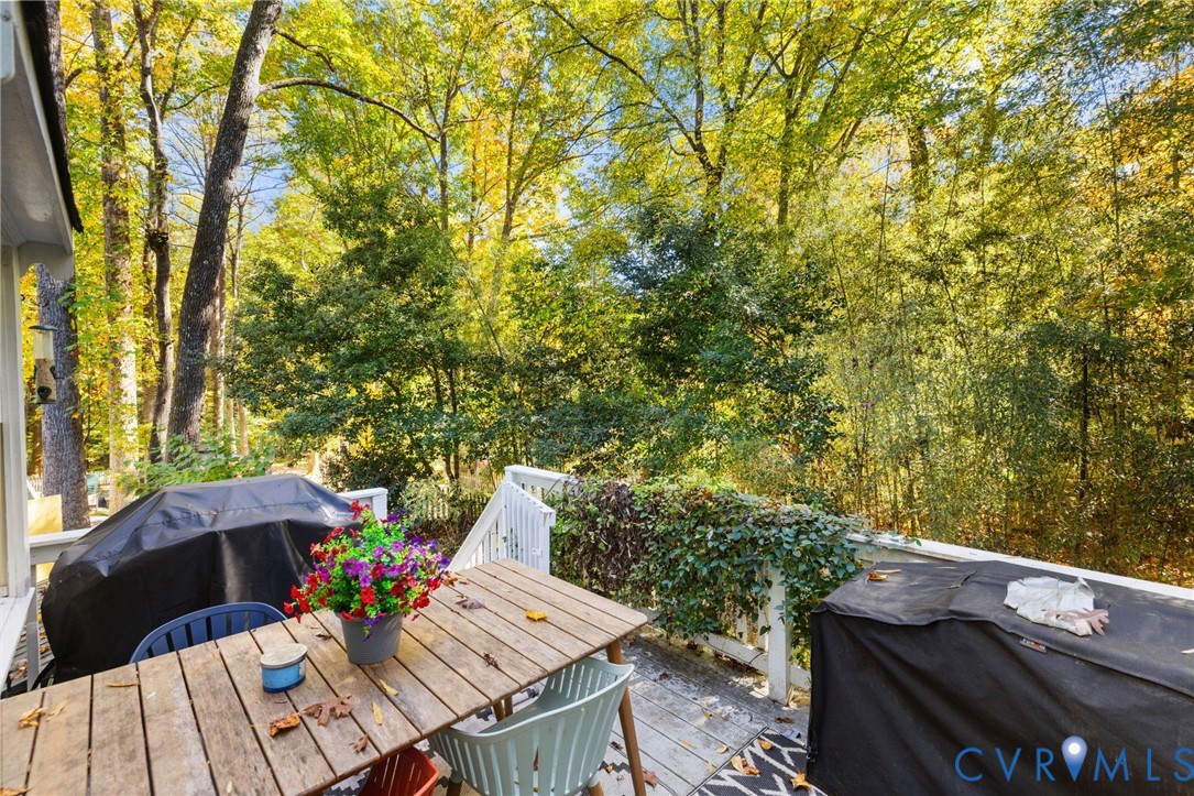 14701 Acorn Ridge Place Midlothian, VA 23112 - Photo 22 of 26 a view of a patio with table and chairs under an umbrella with large trees