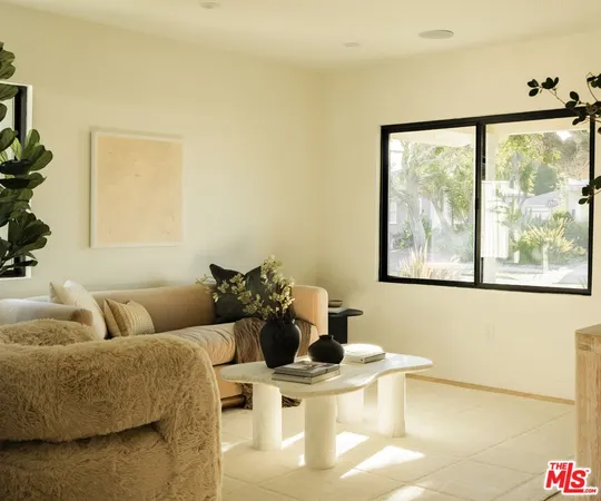 a living room with couches and a large window with outer view