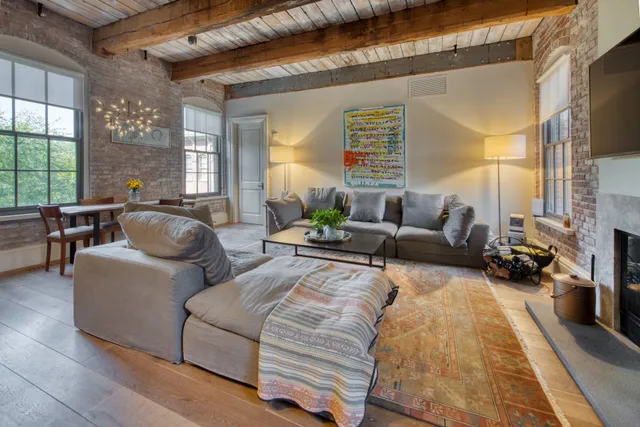 a living room with furniture fireplace and a large window