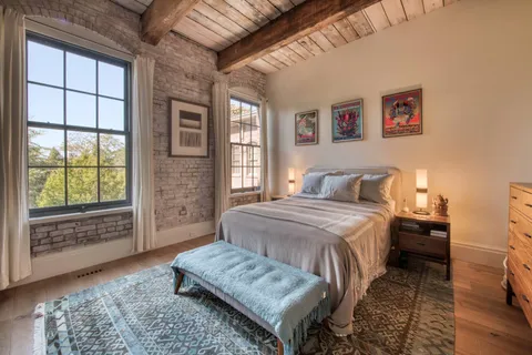 a bedroom with a bed and a large window