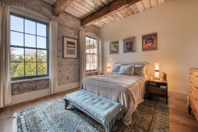 a bedroom with a bed and a large window