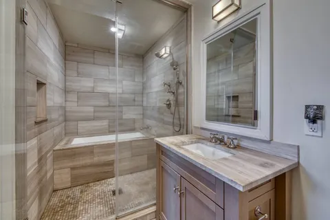 a bathroom with a sink shower and a mirror