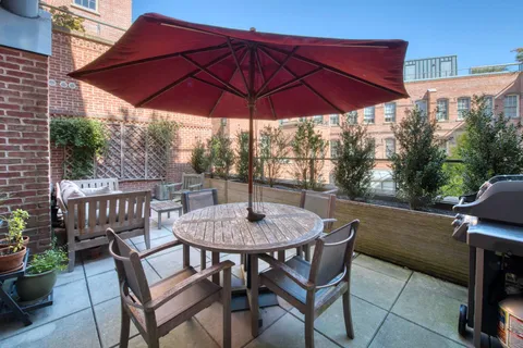 a patio with a table and chairs under an umbrella