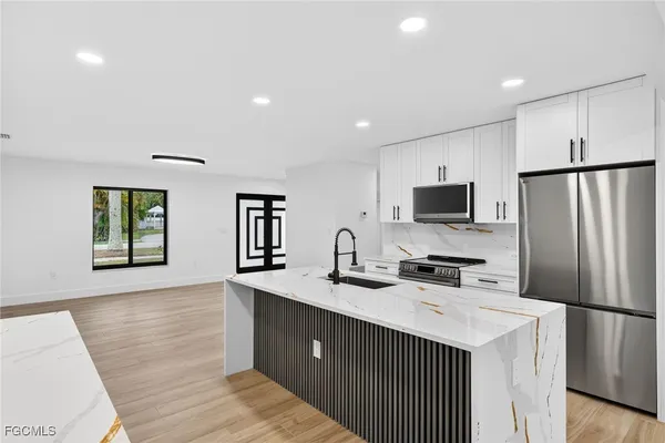 a kitchen with a sink a stove and cabinets