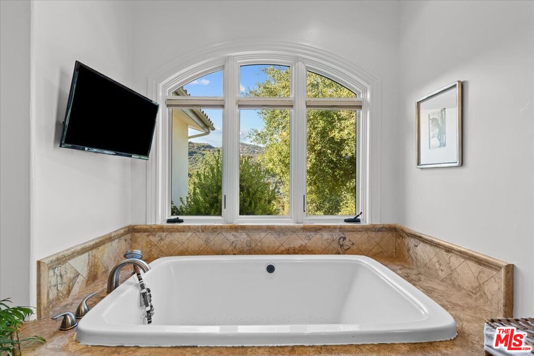 2373 Tuna Canyon Road Topanga, CA 90290 - Photo 25 of 54 a bath tub sitting in a bathroom next to a window