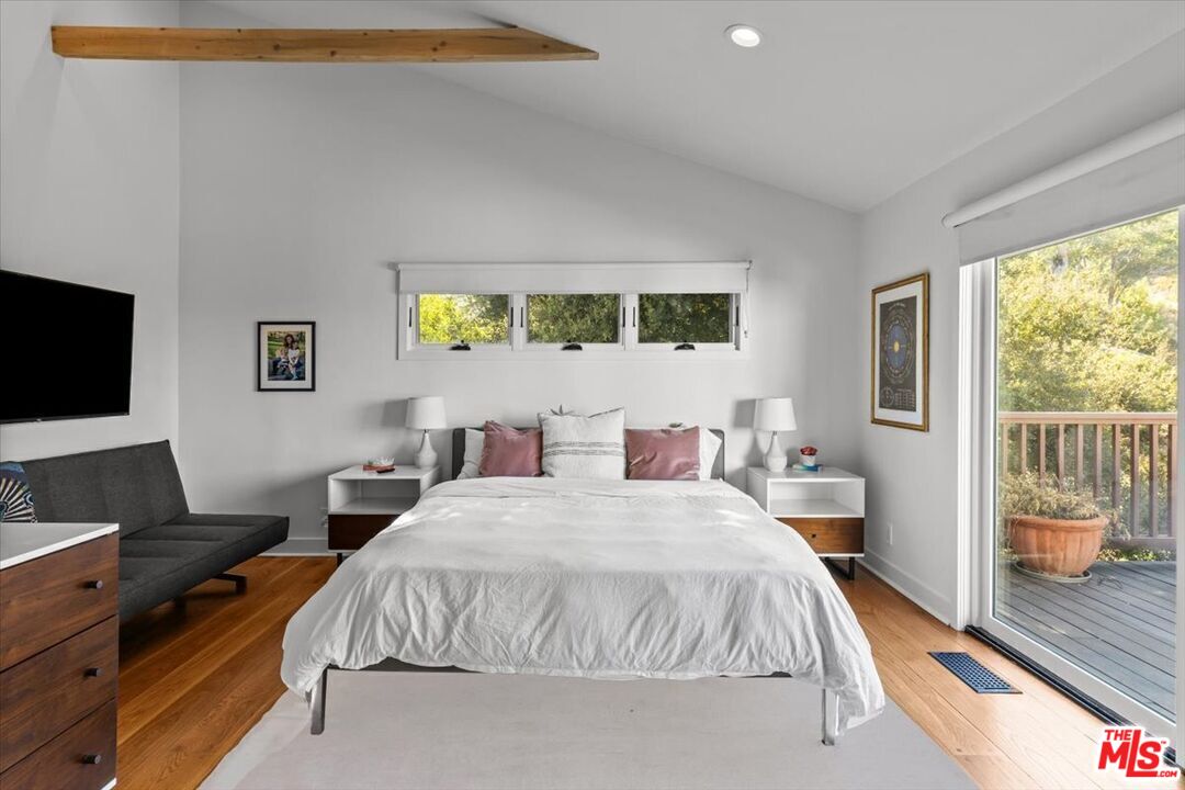 2373 Tuna Canyon Road Topanga, CA 90290 - Photo 27 of 54 a bedroom with a bed and a flat tv screen next to a window