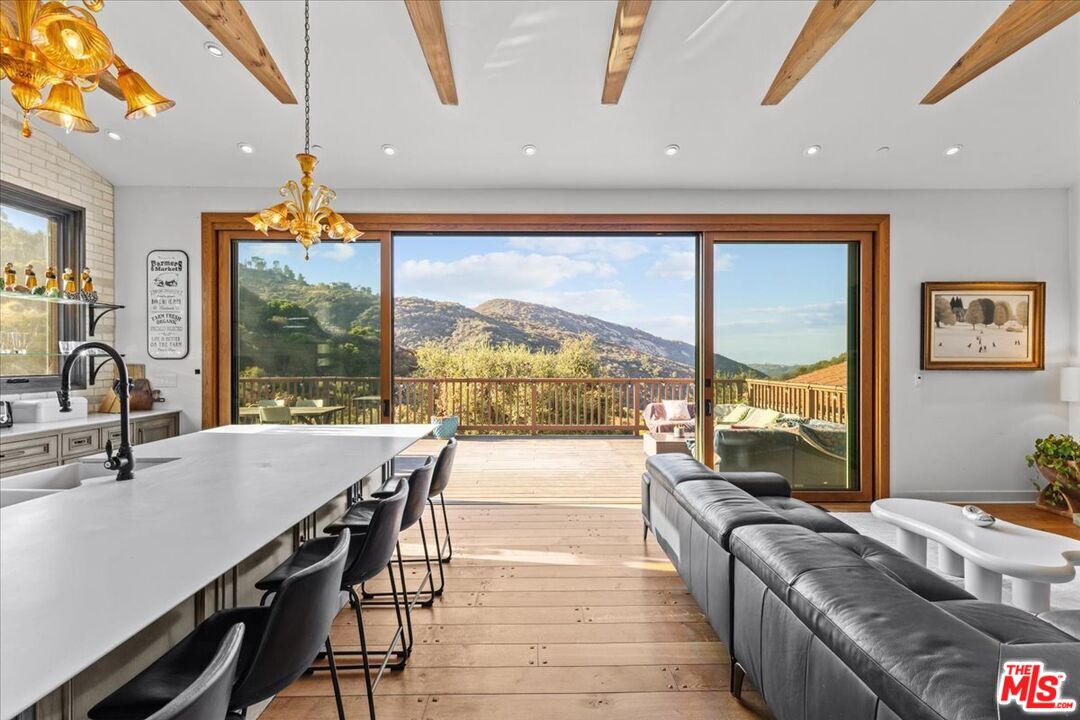 2373 Tuna Canyon Road Topanga, CA 90290 - Photo 3 of 54 a dining room with furniture a chandelier and wooden floor