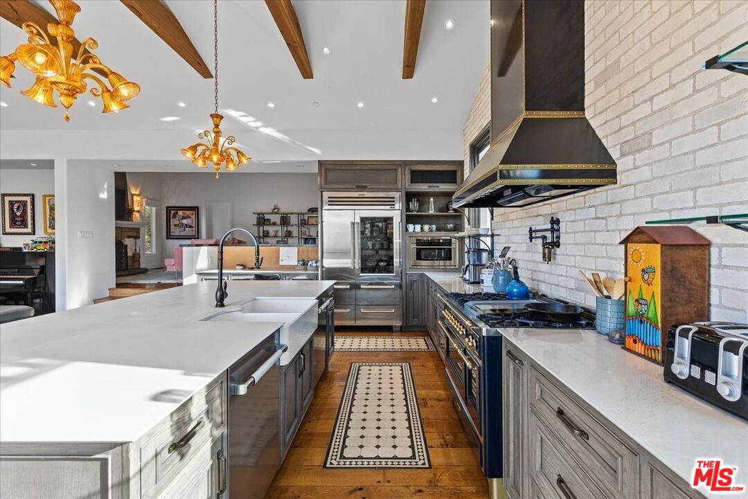 2373 Tuna Canyon Road Topanga, CA 90290 - Photo 6 of 54 a kitchen with stainless steel appliances granite countertop a table and chairs in it