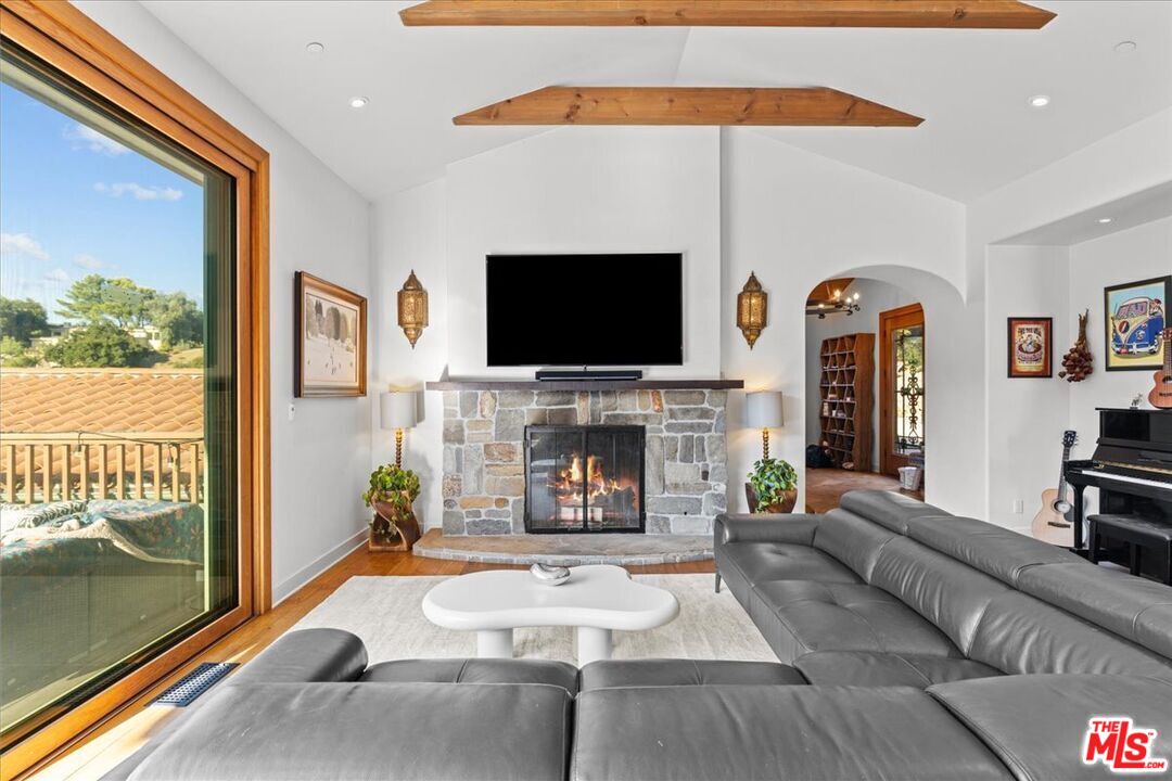 2373 Tuna Canyon Road Topanga, CA 90290 - Photo 8 of 54 a living room with furniture a fireplace and a flat screen tv