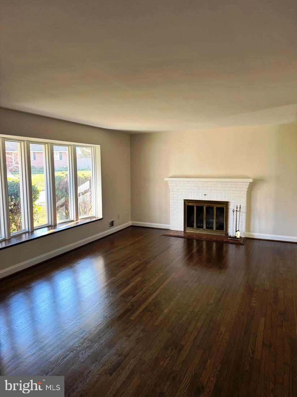 116 Gorsuch Road Lutherville-Timonium, MD 21093 - Photo 13 of 27 an empty room with wooden floor and fireplace