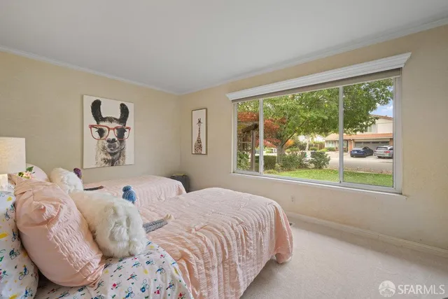 a bedroom with a bed and a lamp on dresser