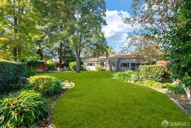 a view of backyard with seating area and green space