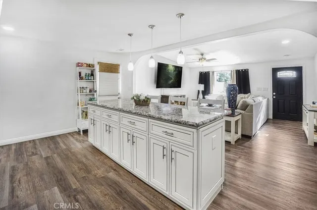 a large white kitchen with kitchen island white cabinets and wooden floor