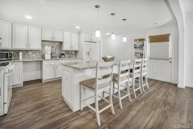 a kitchen with kitchen island cabinets and chairs in it