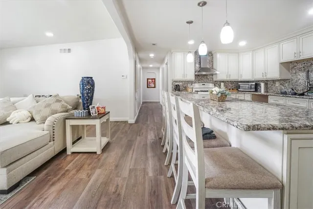 a kitchen with kitchen island granite countertop appliances cabinets and chairs