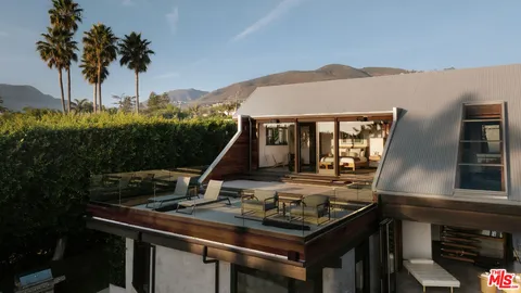 a view of a house with pool and sitting area