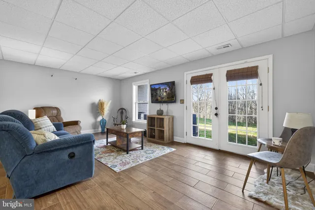 a living room with furniture a flat screen tv and a large window