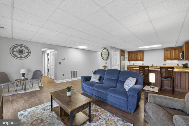 a living room with furniture kitchen view and a window