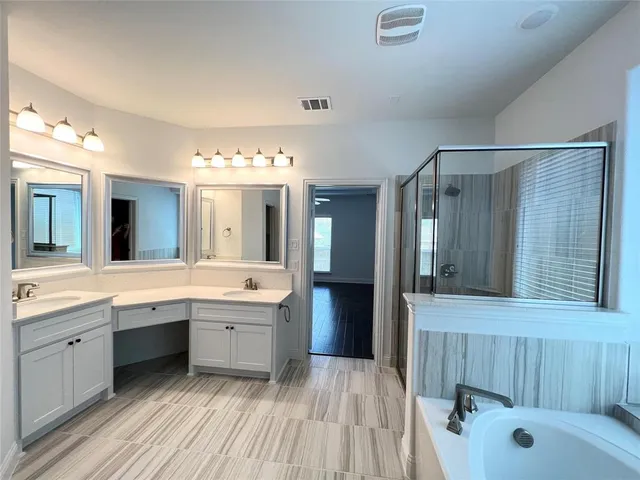 a spacious bathroom with a tub sink and mirror