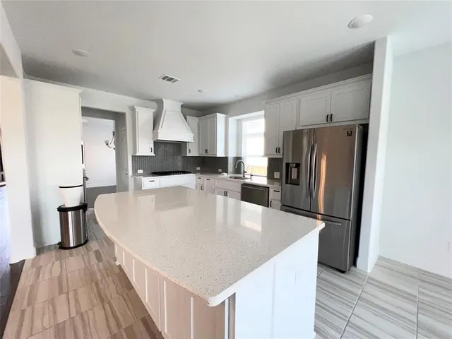 a kitchen with stainless steel appliances a refrigerator and a stove