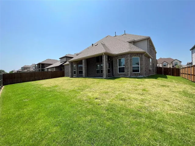a view of a house with a big yard and large trees
