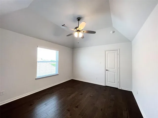 a view of an empty room with a window and a fan