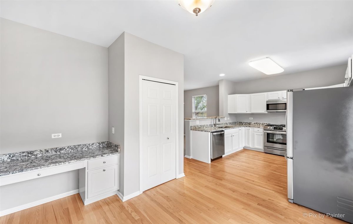 172 East River Road, Unit L Des Plaines, IL 60016 - Photo 16 of 27 a kitchen with granite countertop a refrigerator and a stove top oven