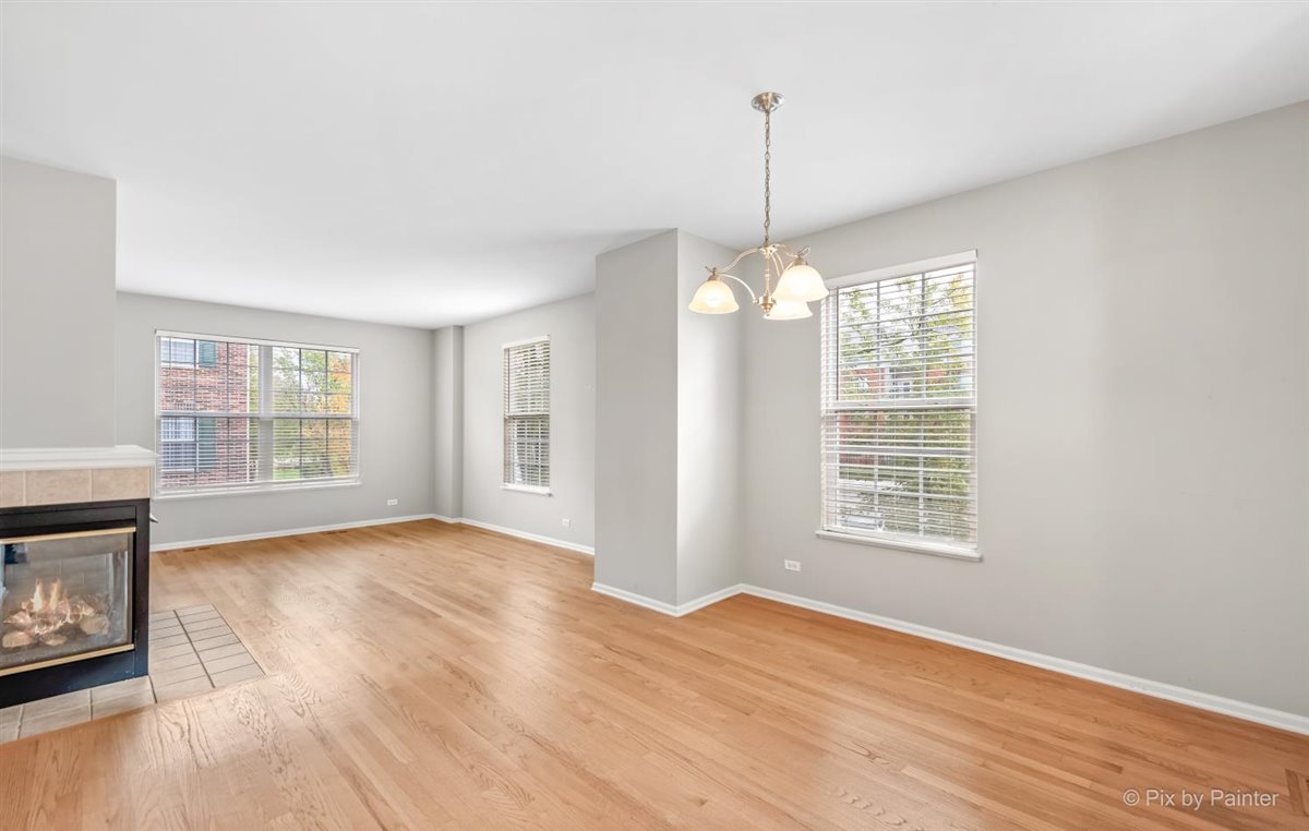 172 East River Road, Unit L Des Plaines, IL 60016 - Photo 9 of 27 a view of a room with wooden floor chandelier and a kitchen