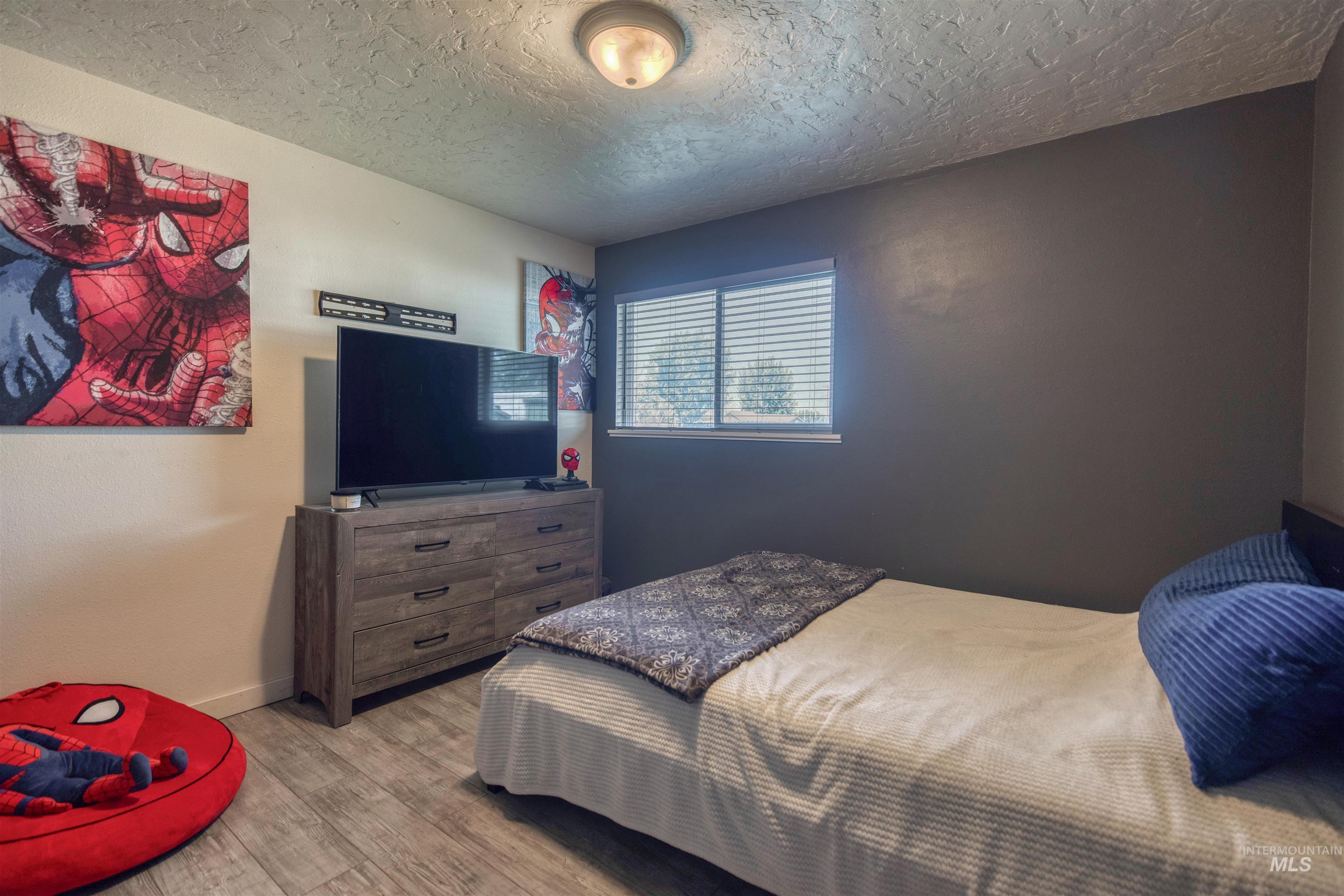 20803 Friends Road Greenleaf, ID 83626 - Photo 16 of 39 Interior room featuring wood-finish flooring, a window with horizontal blinds, and a built-in flush-mount ceiling light fixture