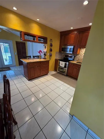 a kitchen with stainless steel appliances a refrigerator and a stove top oven