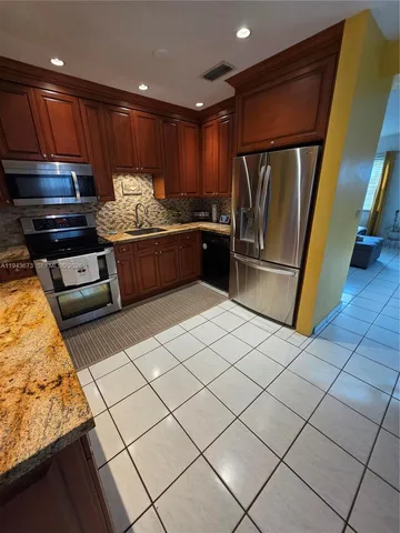 a kitchen with stainless steel appliances a stove a sink and a refrigerator