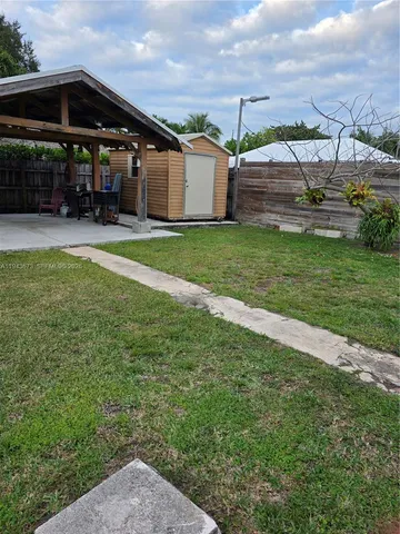 a view of a house with a yard and sitting area