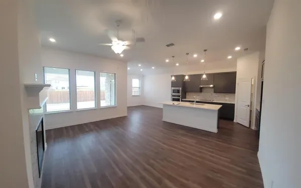 a view of kitchen with kitchen island stainless steel appliances counter space and wooden floor