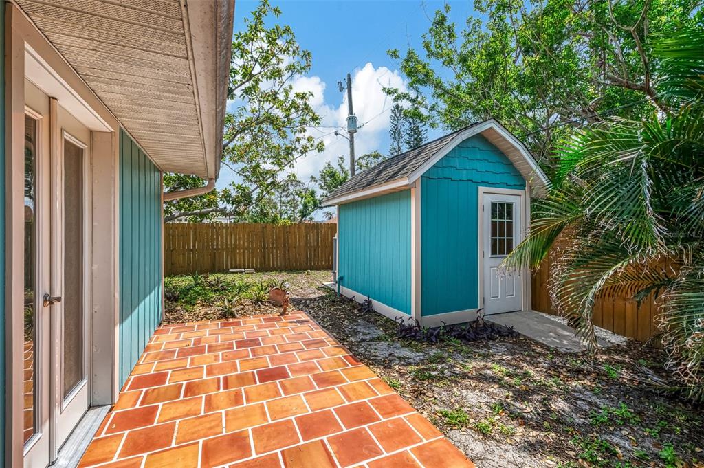 1137 Ponderosa Road Venice, FL 34293 - Photo 38 of 48 a view of a backyard with potted plants and wooden fence