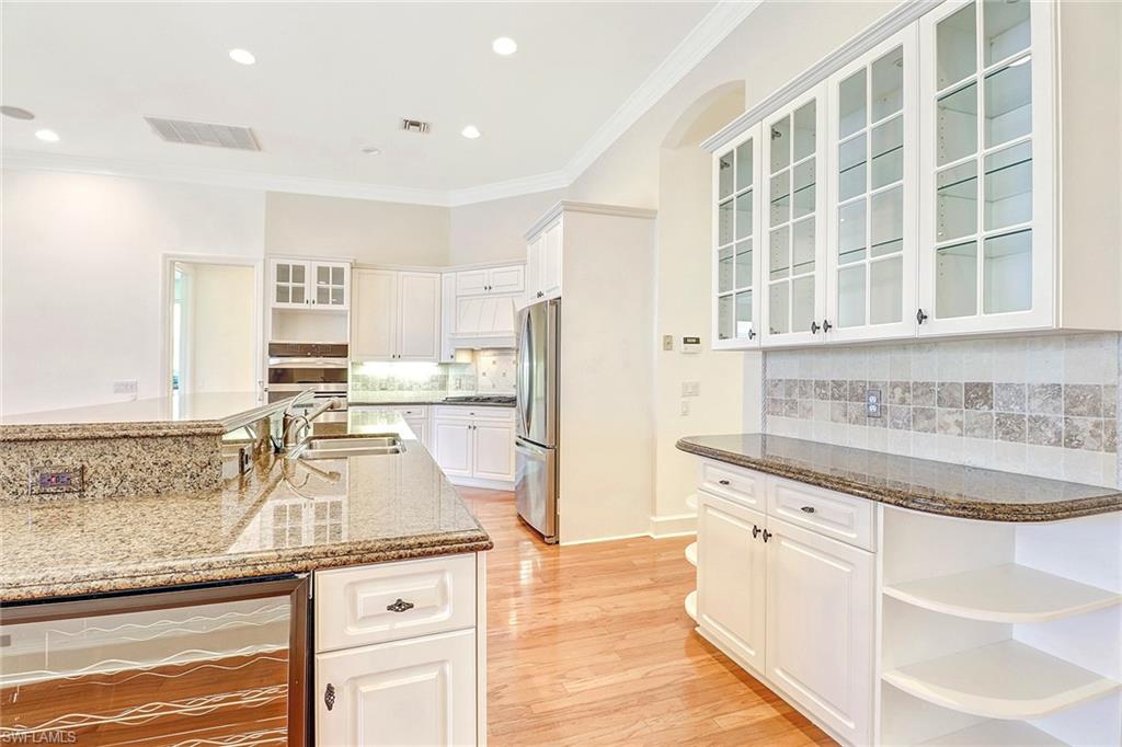 263 Monterey Drive Naples, FL 34119 - Photo 11 of 35 a kitchen with granite countertop a sink and white cabinets