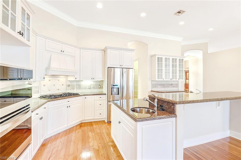 263 Monterey Drive Naples, FL 34119 - Photo 13 of 35 a kitchen with granite countertop a sink stove and refrigerator