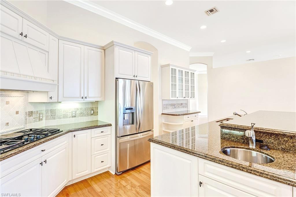 263 Monterey Drive Naples, FL 34119 - Photo 14 of 35 a kitchen with granite countertop a sink stainless steel appliances and cabinets