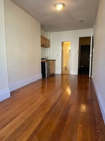 a view of empty room with wooden floor
