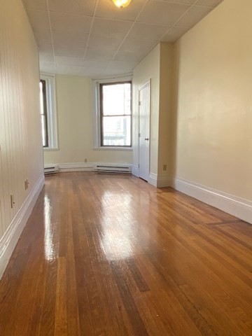 505 Beacon Street, Unit 5 Boston, MA 02215 - Photo 3 of 5 an empty room with wooden floor and windows