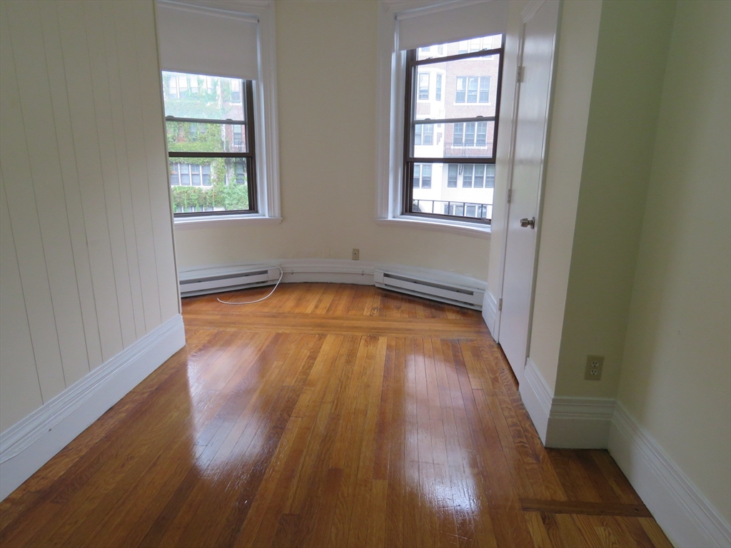 505 Beacon Street, Unit 5 Boston, MA 02215 - Photo 4 of 5 an empty room with wooden floor and windows