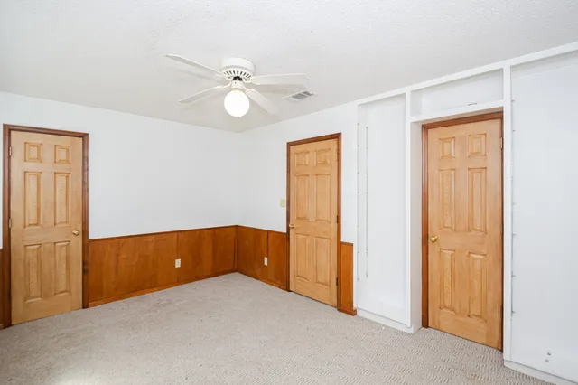 an empty room with closet and fan