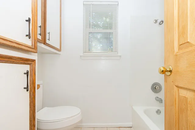 a bathroom with a granite countertop window a toilet and a shower