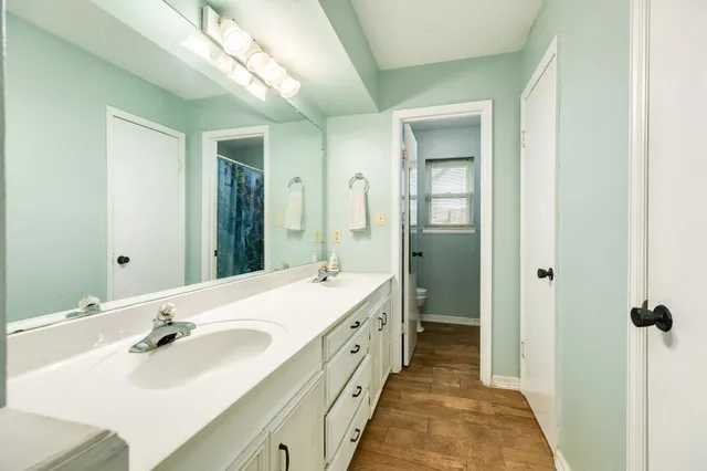 a spacious bathroom with a double vanity sink and mirror