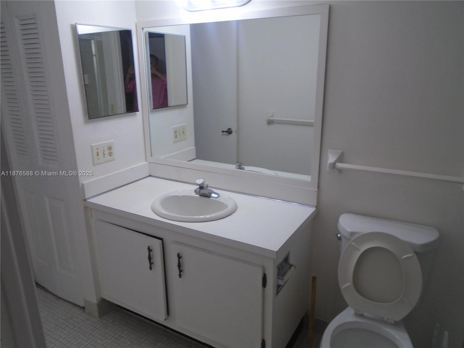 4176 Inverrary Drive, Unit 209 Lauderhill, FL 33319 - Photo 11 of 15 a bathroom with a sink toilet and mirror