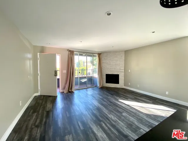 an empty room with wooden floor and fireplace