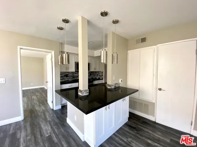 a kitchen with stainless steel appliances granite countertop a sink and a refrigerator
